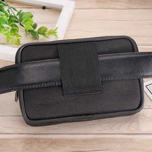 Detailed back view of a black nylon waist pouch attached to a leather belt via webbing loops