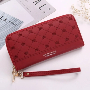 Red long wallet with crown embroidery and diamond stitching on a fashion magazine background