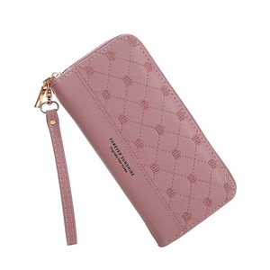 Detail of pink quilted wallet featuring crown embroidery and zip closure with wrist strap