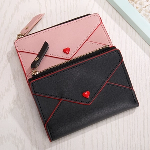 Close-up of heart-accented envelope style PU leather wallets with metallic zippers