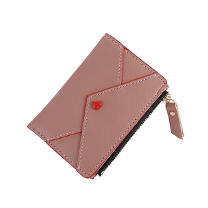 Close-up of dusty pink PU leather wallet featuring a red heart clasp and gold zipper detail
