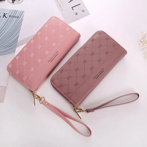 Detail of long quilted women's wallets with crown embroidery and gold hardware