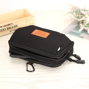 Detail view of black nylon waist bag with three zip pockets and metal carabiner hook