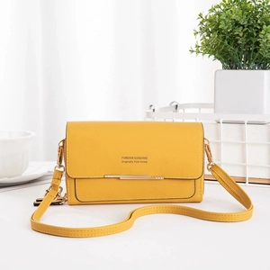 Detail of yellow leather crossbody bag with golden metal trim and Forever Sunshine logo