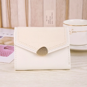 Detail of snake pattern heart wallet featuring gold pebble buckle and creamy leather texture