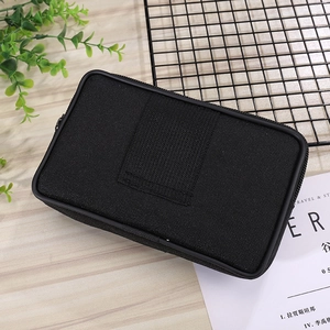 Detailed view of a black canvas phone holster pouch with heavy-duty zipper on a wooden table
