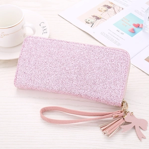 Detailaufnahme einer rosa Glitzer-Geldbörse mit Quaste, Bogenanhänger und Handschlaufe