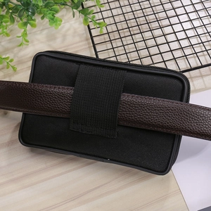 Rear view of a black canvas waist bag showing the wide belt loop and zipper closure