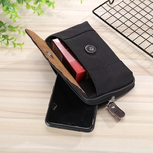 Detail view of black canvas phone waist pouch with magnetic flap and zip compartments