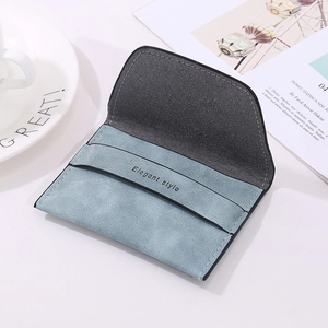 Detail of grey-blue frosted envelope wallet with Elegant style text next to a coffee cup