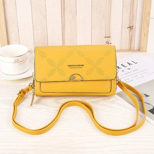 Detail of yellow crossbody phone bag with hollow polka dots and gold ring buckle