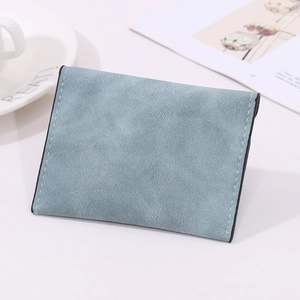 Detail view of ultra-slim matte leather card holder with grey-blue finish and white stitching