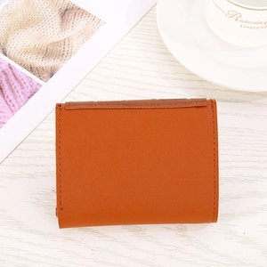 Detail of orange faux leather heart wallet with brown snake-skin textured trim