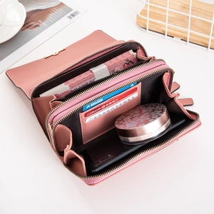 Interior detail of pink leather wallet showing three-layer zippers and large capacity