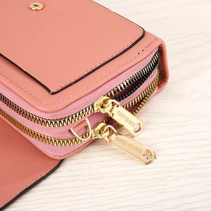 Detail of light pink PU leather bag showing dual gold zippers and forever young engraving