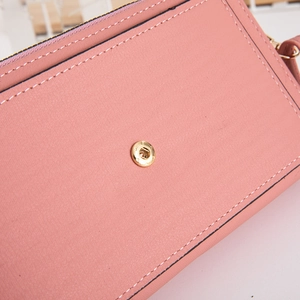 Detail of pink textured faux leather wallet with premium golden metal snap closure