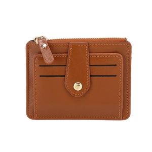 Detail view of brown leather card holder featuring gold zipper and metal snap closure