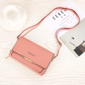Detail of pink crossbody wallet bag with gold metal bar and Forever Young logo text