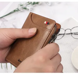 Close-up of brown men's short leather wallet with zipper detail and tricolor ribbon accent