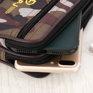 Close-up of camo canvas waist bag showing double zippers and two-phone capacity