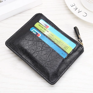 Detail view of black textured leather wallet with three card slots and metal zipper