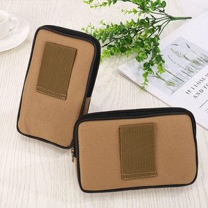 Tactical canvas waist bag and phone pouch in khaki shown on a wooden office desk
