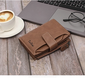 Brown vintage leather wallet with card slots and side zipper on a wooden office desk