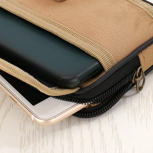 Detail view of khaki canvas waist bag with dual zippers and multi-compartment storage