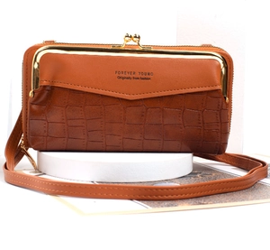 Detail of brown faux crocodile leather bag with gold metal clasp and adjustable strap