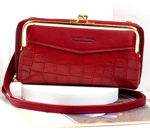 Detail of red stone texture crossbody phone bag with vintage gold clasp and strap