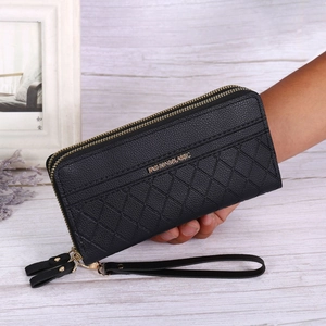 Detail of black pebbled leather clutch with quilted patterns and double zippers