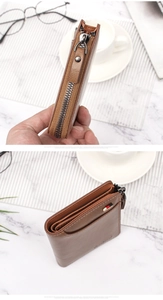 Detail view of brown leather wallet with metal zipper and signature striped accent