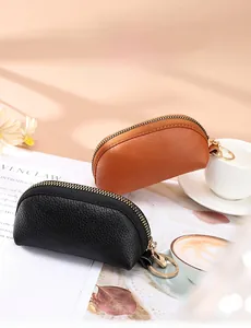 Detail of synthetic leather coin purses with zipper and keychain in black and brown colors