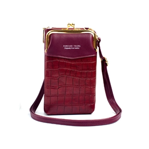 Detail of burgundy crossbody phone bag with faux crocodile pattern and gold clasp