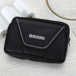 Detail of lychee pattern leather men's waist bag with dual zippers on wood background