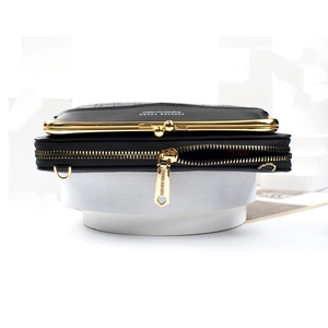 Detail view of black crocodile pattern phone bag with golden clasp and zippers