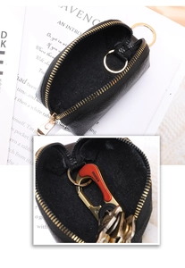 Close-up of black lychee grain leather coin purse with golden metal zipper and key ring