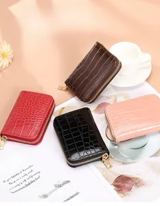 Detail of stone-patterned zip card holders in brown red black and pink leather