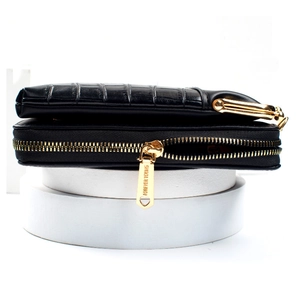 Macro detail of crocodile pattern leather wallet with gold Forever Young metal zipper