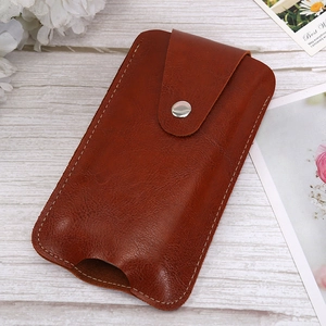 Close-up of caramel brown leather belt pouch with silver snap and white stitching
