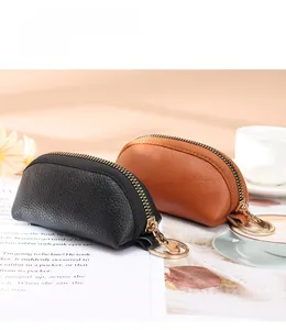 Detailed view of semi-circular lychee grain leather coin purses in black and brown colors