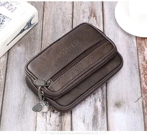 Vue détaillée du sac banane en cuir marron à trois zips posé sur un bureau en bois