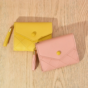 Detail view of diamond quilted women's wallet with snap closure and tassel charms