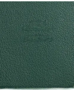 Gros plan détaillé du cuir vert foncé avec texture litchi d'un portefeuille pour femmes