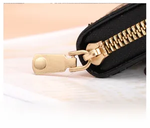 Detailed close-up of premium golden metal zipper on black stone pattern wallet