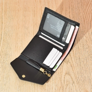 Detail of black tri-fold wallet showing interior card slots and leather texture