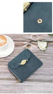 Detail of blue matte leather wallet with golden leaf clasp and smooth metal snap button