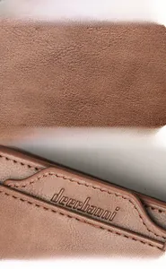 Close-up of brown leather wallet texture with fine stitching and embossed logo
