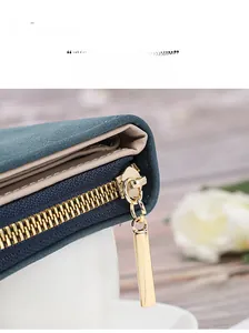 Close-up of premium gold-plated zipper on dark green leather wallet with smooth motion