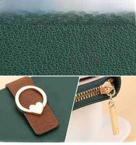 Détail du portefeuille en cuir grainé vert foncé avec cœur doré et fermeture éclair métallique